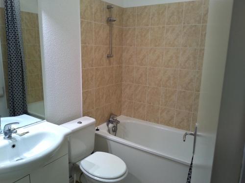 een badkamer met een wastafel, een toilet en een bad bij Appartement 39 M² 2/4 personnes avec piscine in Aspin-en-Lavedan