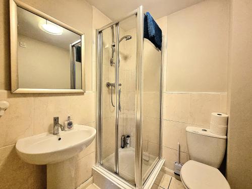 a bathroom with a shower and a sink and a toilet at Spacious 4 Bed Family Home with Private Garden & Free Parking - Hamilton in Leicester