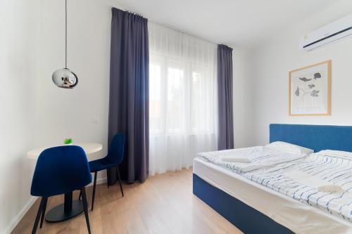 - une chambre avec un lit, une table et une chaise dans l'établissement Villa Oliver Budapest, à Budapest