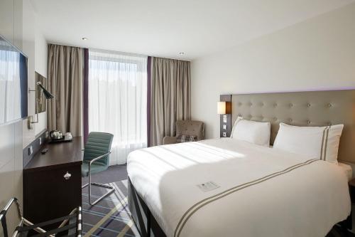 a hotel room with a large bed and a desk at Premier Inn Hamburg City Zentrum in Hamburg