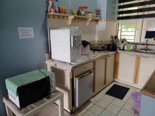 a kitchen with a microwave sitting on top of a counter at A.ghanis Homestay Port Dickson in Port Dickson