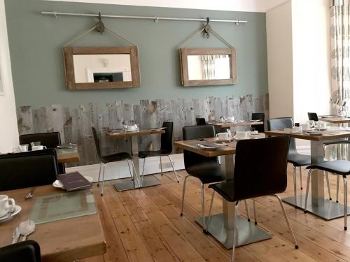 a dining room with tables and chairs and a mirror at St Bernards in Newquay