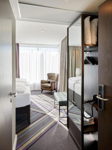 a room with a bedroom with a bed and a chair at Premier Inn Hamburg City Zentrum in Hamburg