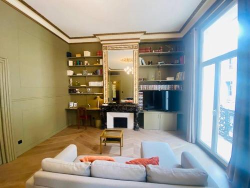 un salon avec un canapé blanc et une cheminée dans l'établissement ''Le Général'' Superbe appartement Haussmanien climatisé en coeur de ville, à Sète