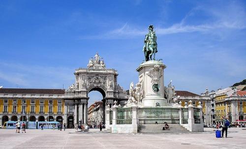 a statue in front of a building with an arch at Apartamento Anjos in Lisbon