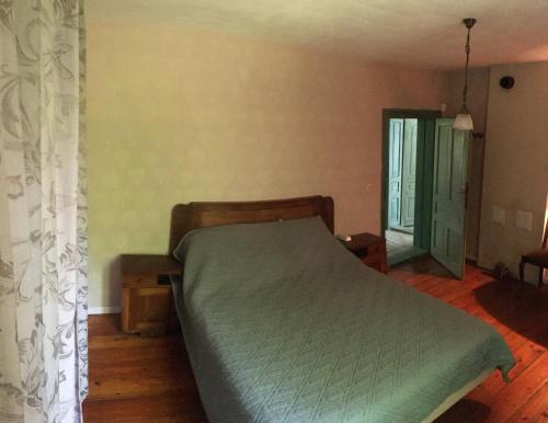 a bedroom with a bed with a green bedspread at "Maroli House" in Vrŭv