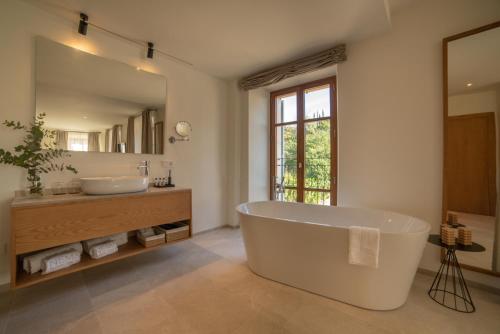 a bathroom with a tub and a large mirror at Nema Boutique Hotel & Spa in Artá
