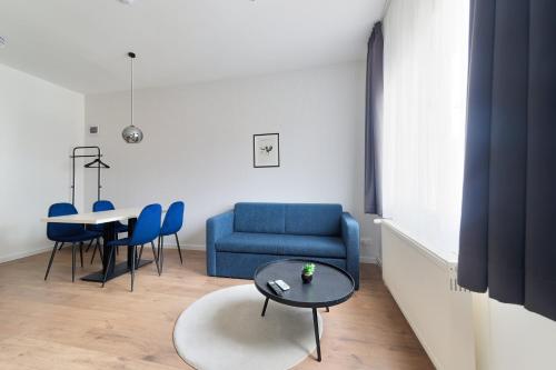 uma sala de estar com um sofá azul e uma mesa em Villa Oliver Budapest em Budapeste