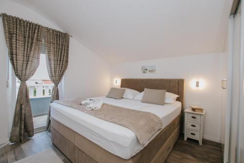 a bedroom with a large bed and a window at Royal Blue House 3 in Kaštela
