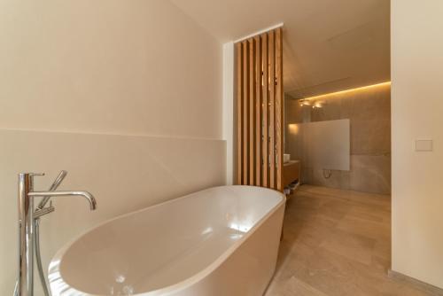 a white bath tub in a white bathroom at Nema Boutique Hotel & Spa in Artá