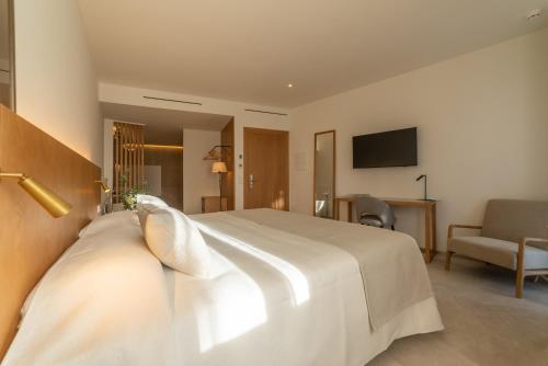 a hotel room with a large white bed and a couch at Nema Boutique Hotel & Spa in Artá