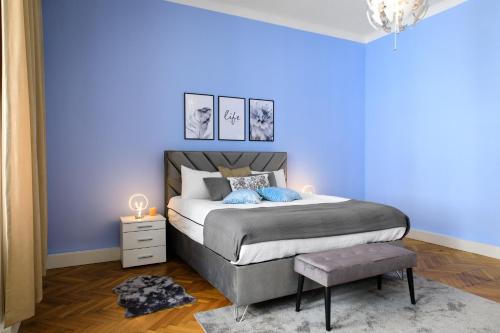 ein blaues Schlafzimmer mit einem Bett und einer blauen Wand in der Unterkunft Infinity Homes - Stylish 3-Bedroom Haven in the Heart of Vienna! in Wien