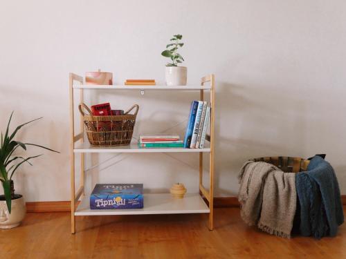 a book shelf with books and a basket on it at Ubytování u Slunských in Valtice