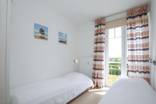- une chambre avec 2 lits et une fenêtre dans l'établissement Achtern Diek Wohnung 14, à Boltenhagen