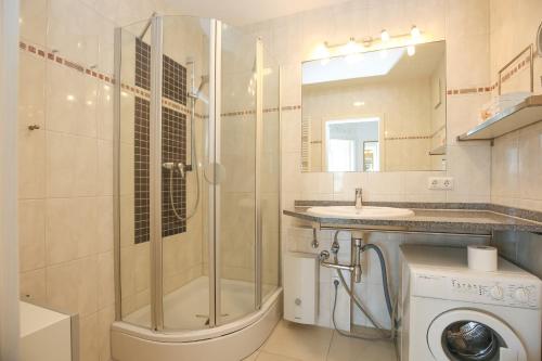 La salle de bains est pourvue d'une douche et d'un lave-linge. dans l'établissement Achtern Diek Wohnung 14, à Boltenhagen