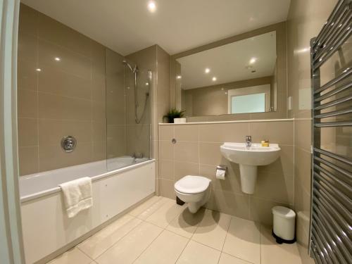 a bathroom with a sink and a toilet and a bath tub at Berks Luxury Serviced Apartments RWH 76 1 Bedroom, 1 super king bed, free parking, gym & wifi in Bracknell