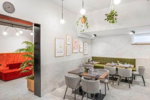 a restaurant with tables and chairs and a red couch at Florin Apart Hotel in Budapest