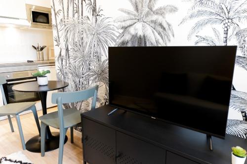 een woonkamer met een grote flatscreen-tv bij Le Tropical - Beau logement centre - Gare - Tram in Le Mans