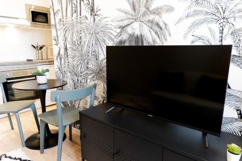 a living room with a large flat screen tv at Le Tropical - Beau logement centre - Gare - Tram in Le Mans