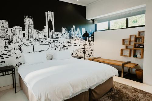 1 dormitorio con 1 cama blanca y una ciudad en blanco y negro en Alpine Attitude Boutique Hotel & Conference Venue, en Pretoria