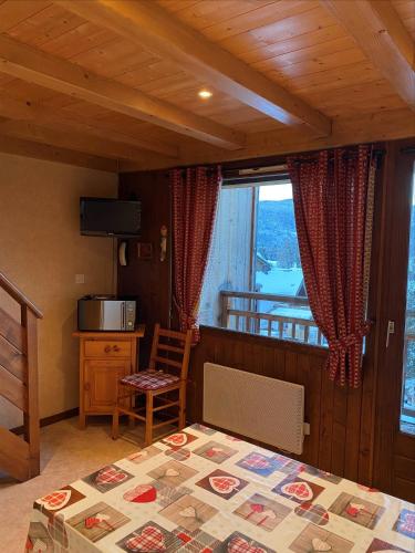 une chambre avec un lit, une table et une fenêtre dans l'établissement Duplex au centre de SAMOENS - 6 couchages, à Samoëns
