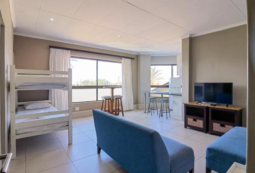 a living room with a bunk bed and a couch and a tv at Ballito Bay Holiday Apartment in Ballito