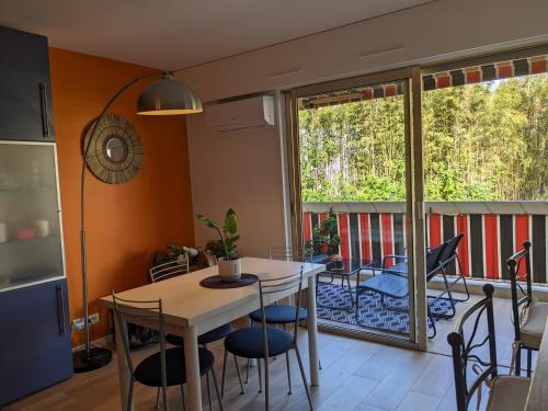 una cucina con tavolo e sedie e un balcone di EDEN GOLFE Plages à pieds Parking Privé a Vallauris