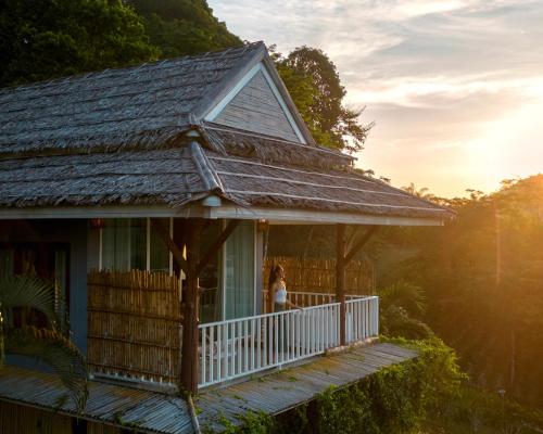a woman standing on the porch of a house at Baan Phuvara Retreat - Romantic Jacuzzi Mountain View Villas in Ao Nang Beach