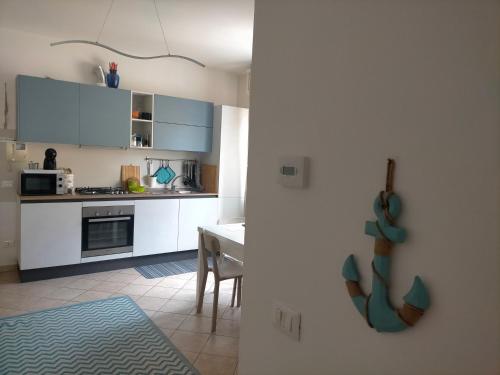 una cocina con armarios blancos y una mesa. en appartamento incantevole a due passi dal mare a Viserbella vicino fiera Rimini en Rímini