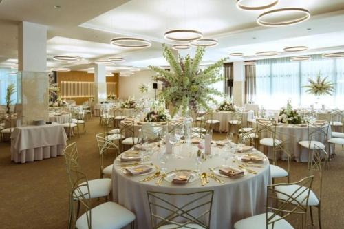 a banquet hall with white tables and chairs at LOFT pri parku in Banská Bystrica