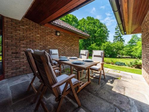 eine Terrasse mit einem Holztisch und Stühlen in der Unterkunft Holiday Home Kunějov by Interhome in Člunek