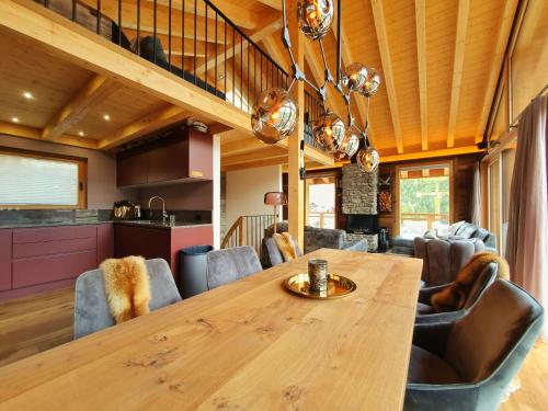 a kitchen and dining room with a wooden table and chairs at Luxury Chalet Engedi in Saas-Fee