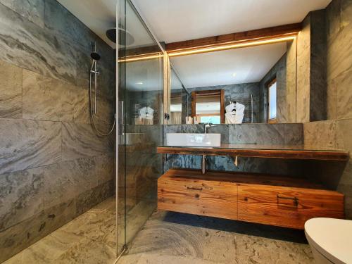 a bathroom with a shower and a sink and a mirror at Luxury Chalet Engedi in Saas-Fee