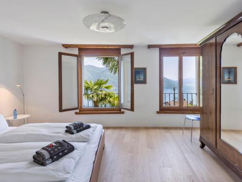 1 Schlafzimmer mit 2 Betten und 2 Fenstern in der Unterkunft Holiday Home Casa Porta by Interhome in Brissago