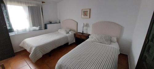 2 camas en una habitación con paredes blancas en Casa Rural Mirador De La Luna, en Hornos