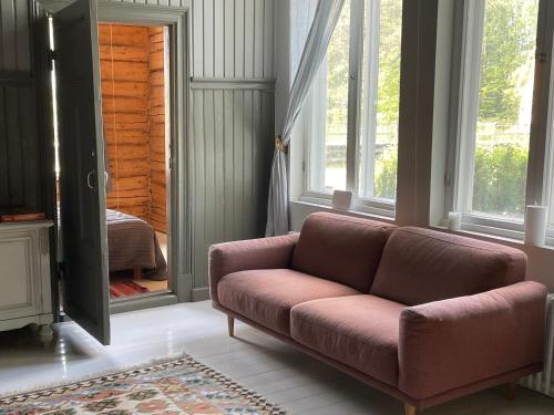 a living room with a couch and a mirror at Stationmaster's studio in Porvoo