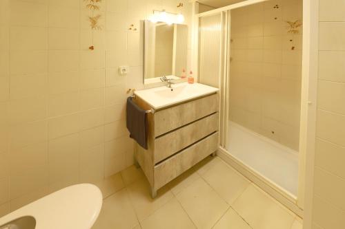 a bathroom with a sink and a toilet and a tub at Los Helechos A1, central 2 bed PDC in Puerto del Carmen