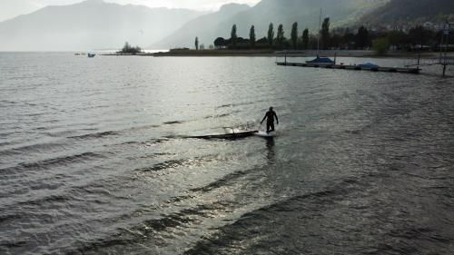 ソーリコにあるCamping Hotel Au Lac De Comoの水中のサーフボードに乗った者