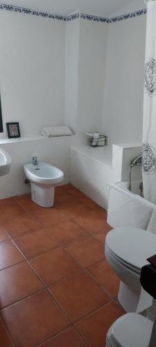 a white bathroom with a toilet and a sink at Casa Rural Mirador De La Luna in Hornos