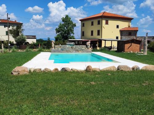 una villa con piscina di fronte a una casa di VILLA GIOVANNA a Capannori