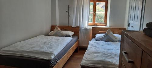a small bedroom with two beds and a window at Nette's Ferienhaus in Landsberg am Lech