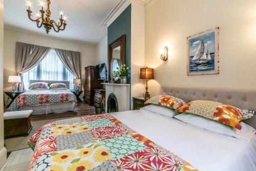 a bedroom with two beds and a chandelier at The Elizabeth Manor Guesthouse in St. John's