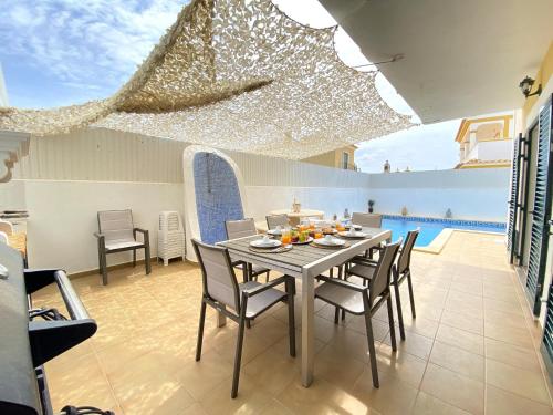 a dining room with a table and chairs at Pêra Amazing Villa With Pool by Homing in Pêra