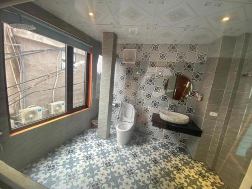 a bathroom with a toilet and a sink and a window at Tam Đảo Xanh Homestay - Venuestay in Vĩnh Phúc