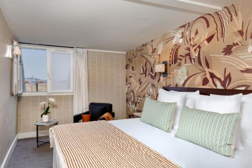 パリにあるル セナのベッドと窓が備わるホテルルーム
