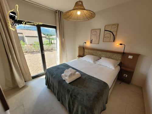 - une chambre avec un grand lit et une grande fenêtre dans l'établissement Villa du Soleil 8 pers piscine chauffée, à Lecci