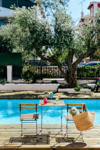 a table and two chairs next to a pool at Oliva Holiday Homes in Dhiyeliótika
