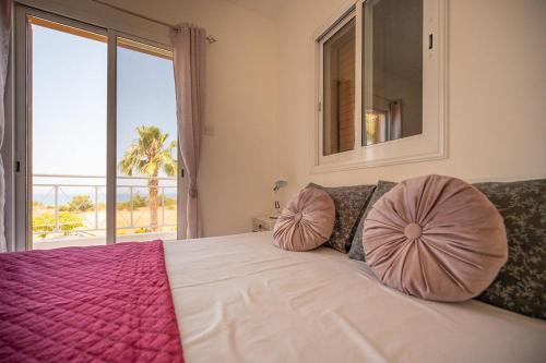 um quarto com uma cama com duas almofadas em Villa Bimini em Argaka