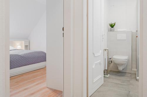 baño blanco con aseo y cama en Kastanienallee 3 Wohnung 7, en Timmendorfer Strand