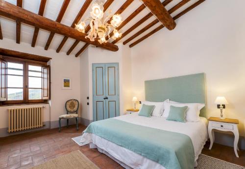 Un dormitorio con una cama grande y una lámpara de araña. en Villa Mille Desideri, en Anghiari